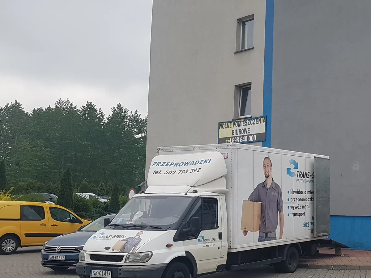 Samochód Trans-Speed zaparkowany przed blokiem podczas przeprowadzki mieszkania